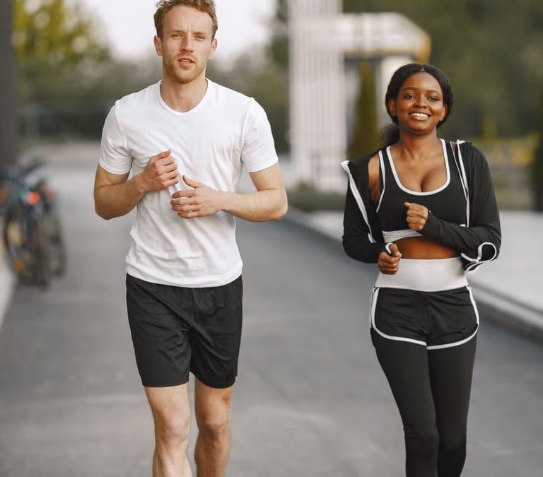 A man and woman jogging together outside, embracing a healthy lifestyle.