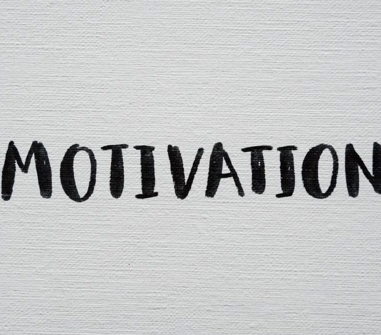 Inspirational word 'Motivation' in black on a white textured canvas background.